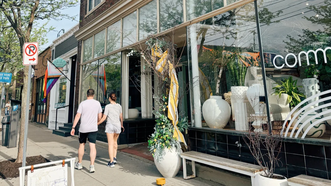 Commune's Cherry Street storefront: big glass display windows with white pottery and the lowercase 'commune' wordmark on the glass, a couple walking past.