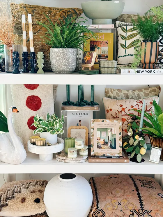 Layered kilim and floral pillows with a Moroccan pouf and coffee-table books.