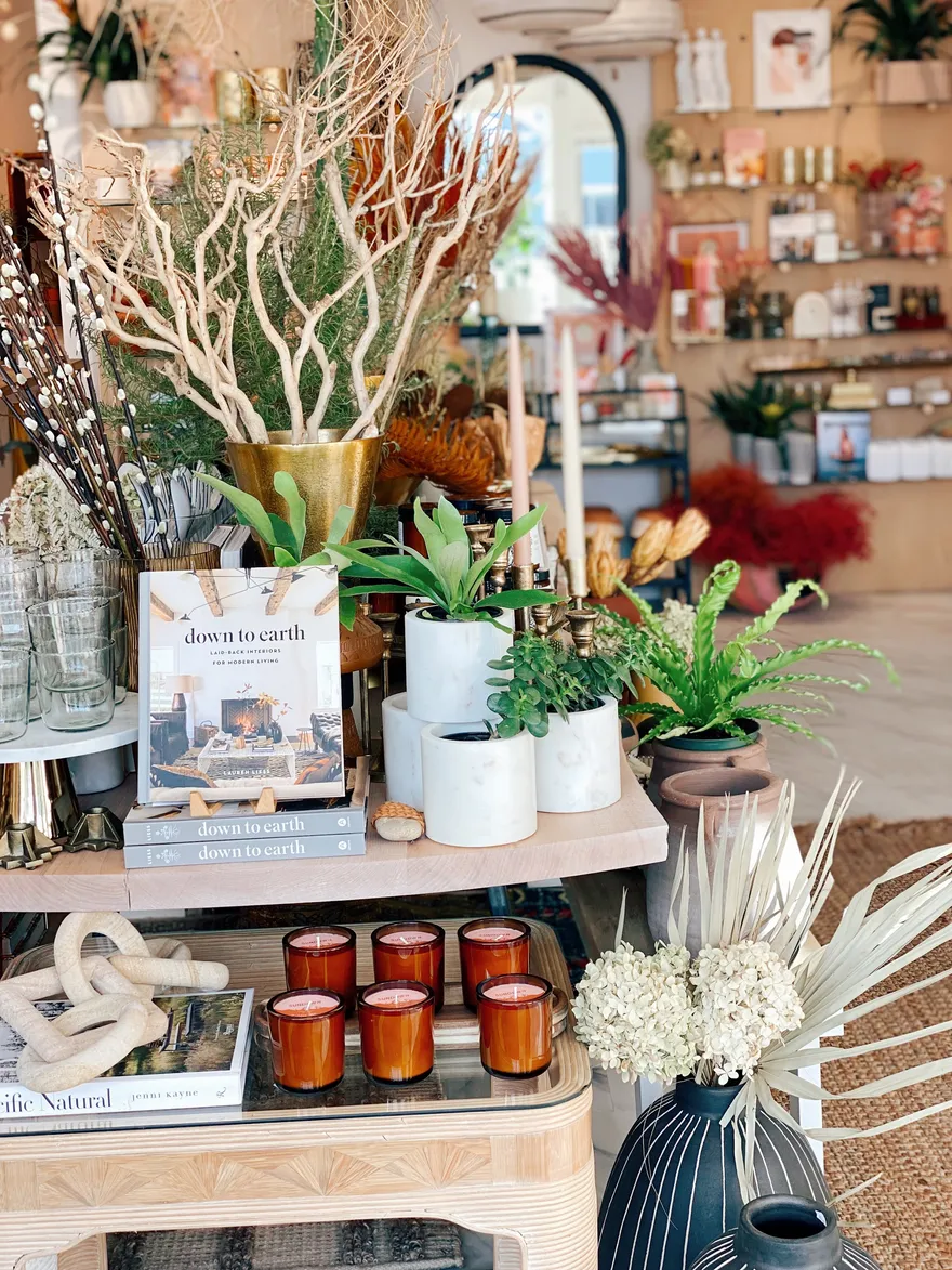 Coffee-table travel books stacked with amber candles and marble planters.